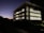 Photo of a sleek, fully finished commercial building illuminated at dusk.