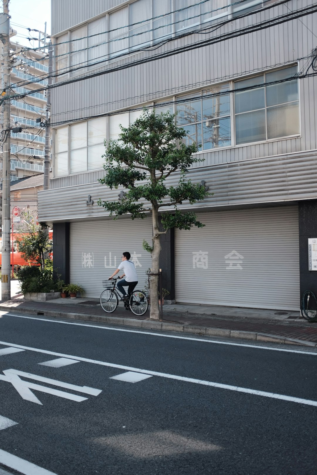 man rides bike near close store on sidewalk