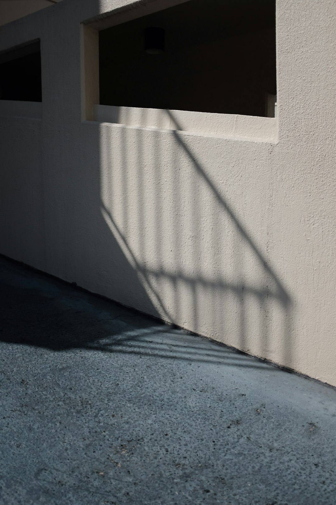 shadow of a stairs railing on white wall