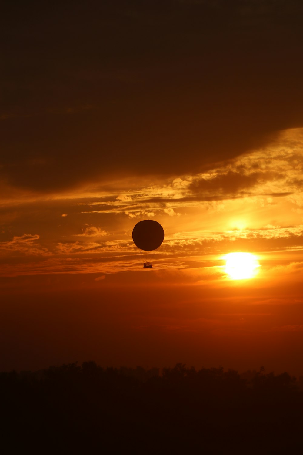 a hot air balloon flying in the sky at sunset