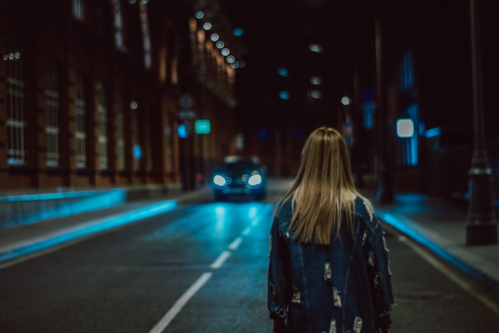 woman standing on road at night