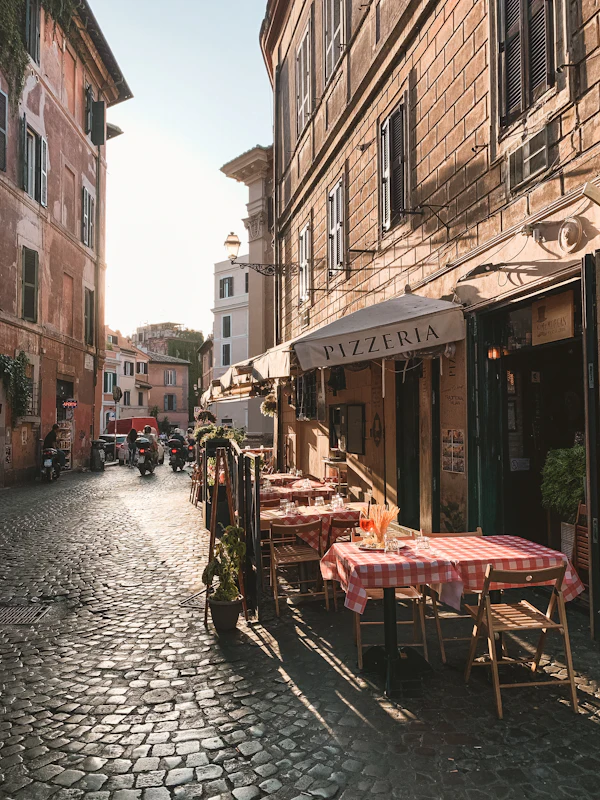 Trattoria tables on a cobblestone street in Trastevere