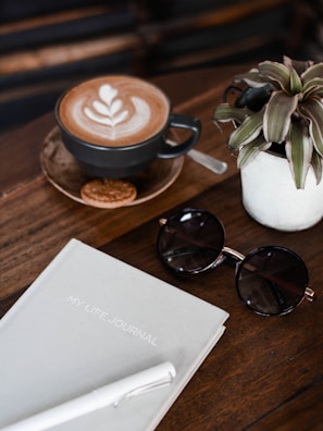 A stylish flat lay of a journal, coffee, and accessories.