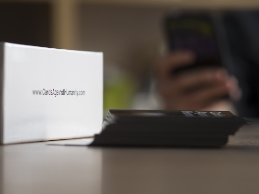 a white box sitting on top of a table next to a cell phone