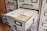 A vintage filing cabinet with multiple drawers, one of which is open, revealing a stack of index cards with labeled tabs.