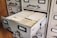 A vintage filing cabinet with multiple drawers, one of which is open, revealing a stack of index cards with labeled tabs.