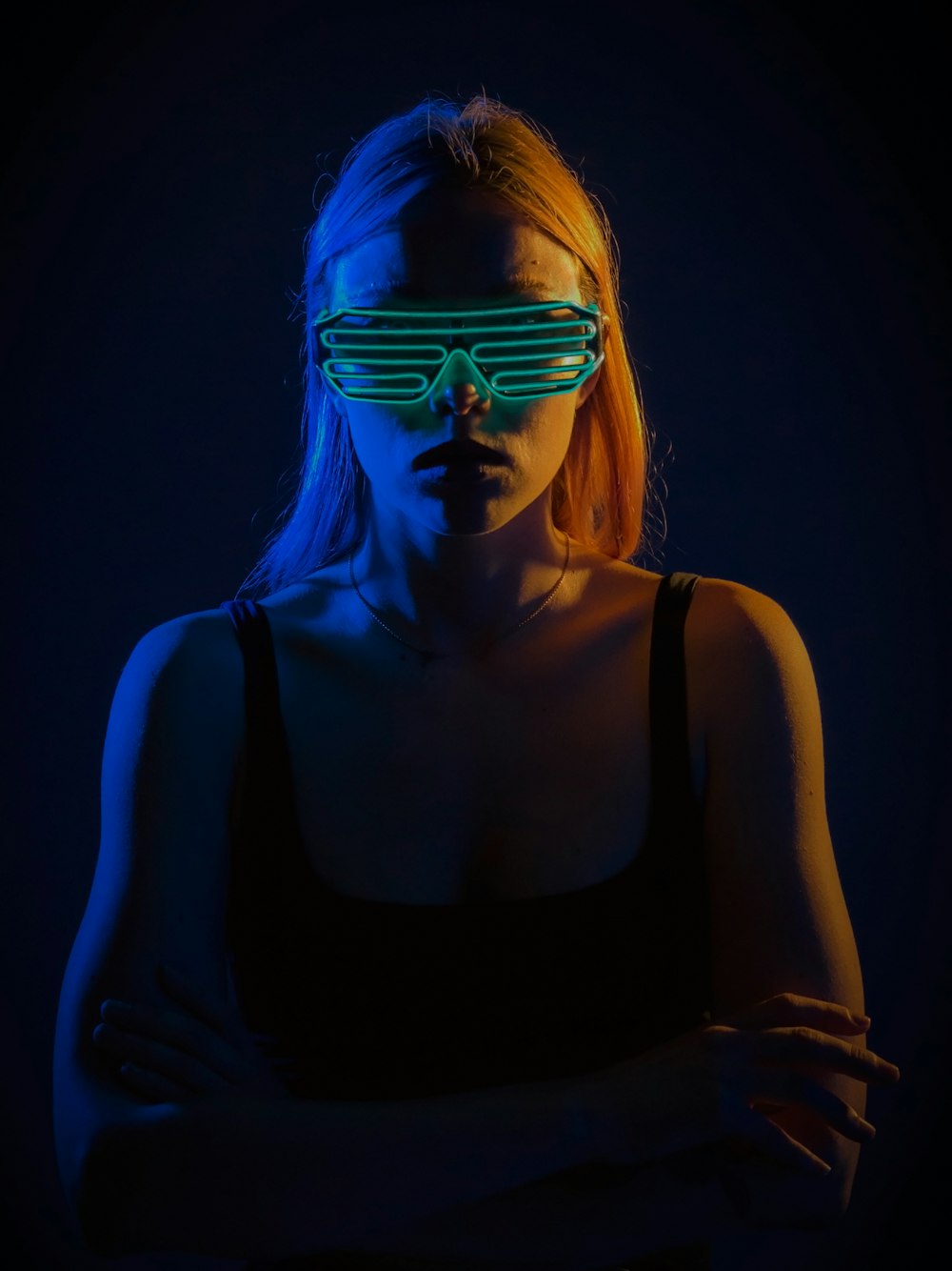 woman wears teal sunglasses in dim light