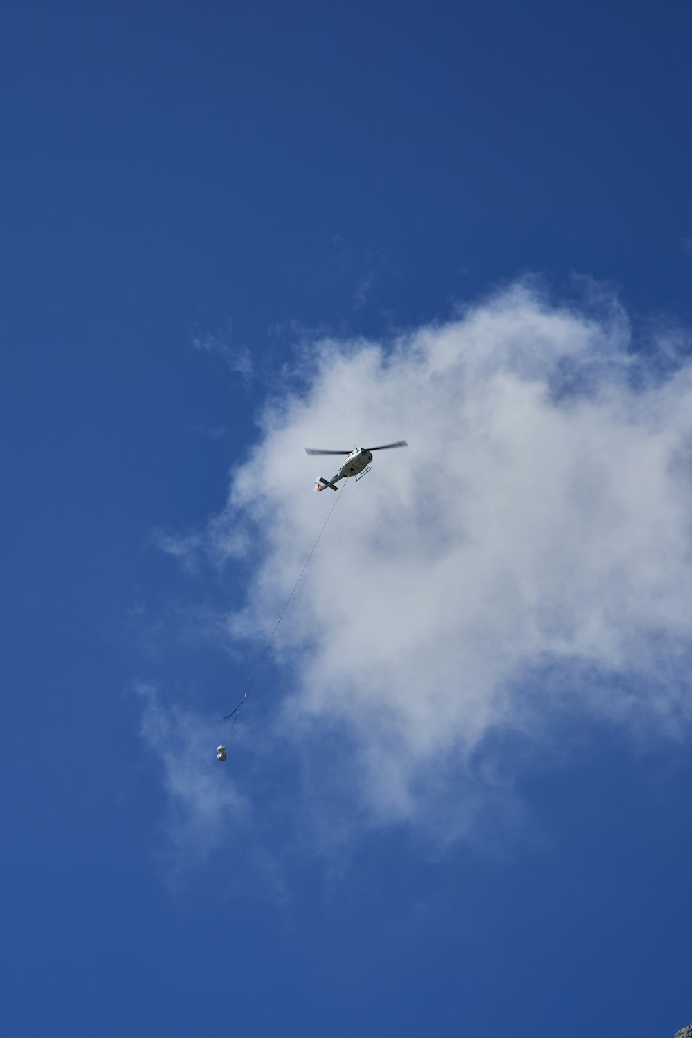 white helicopter under white clouds