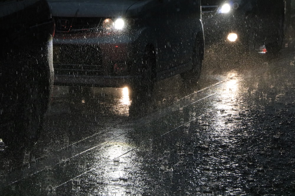 Regentropfen auf Straße und Fahrzeugen