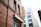 A red-brick building featuring signage for a barbecue restaurant with classic style signage and a neon sign that reads 'BARBECUE' vertically. Adjacent is a white building with multiple windows and an architectural design that contrasts with the rustic look of the brick.