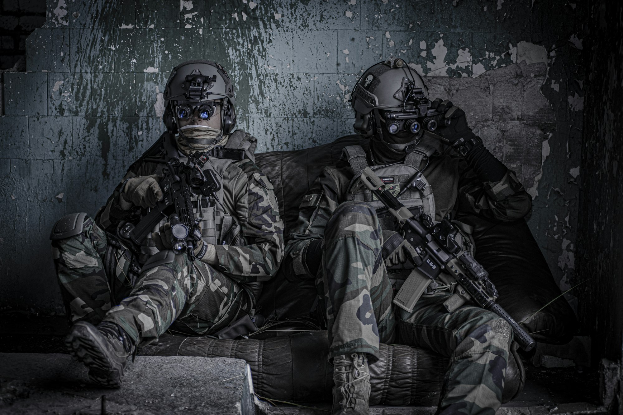 Airsoft players in protective glasses and helmet, with the airsoftgun