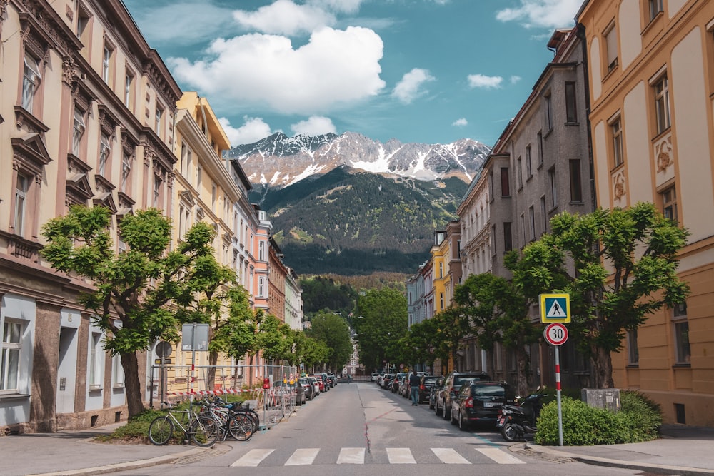 diversi veicoli che parcheggiano vicino agli edifici che osservano la montagna sotto cieli bianchi e blu durante il giorno