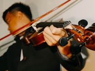 An instructor guiding a young violinist through a delicate passage during a private lesson.