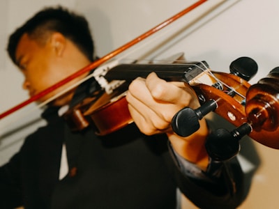 An instructor demonstrating violin techniques to eager learners.