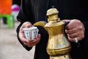 person holding teapot and teacup