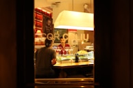 A lively restaurant scene showing friends laughing and sharing dishes over glasses of wine.