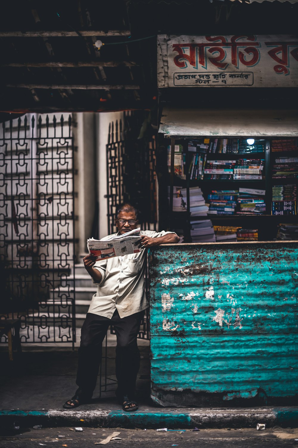 woman reading newspaper near stall