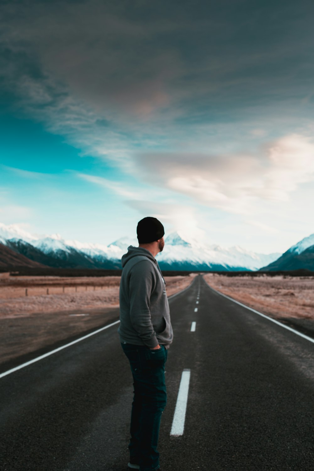 man standing on empty road