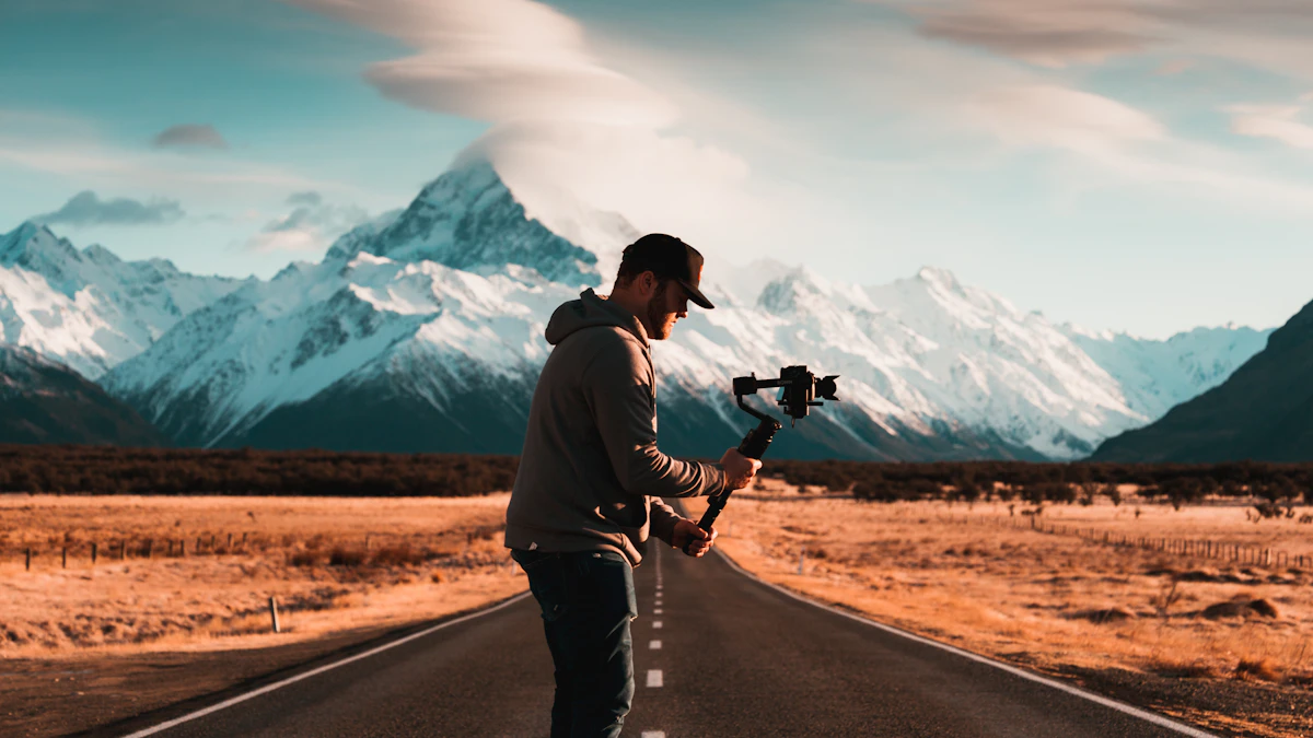 A man adjusting a gimbal on an empty narrow road