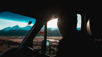 A satisfied passenger smiling inside a taxi with scenic Austrian mountains visible through the window.