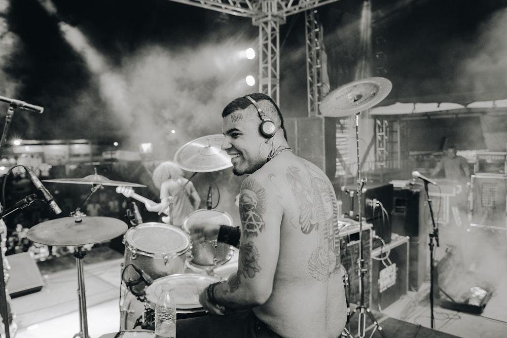 grayscale photo of man playing drum