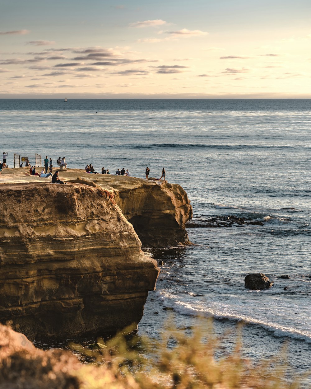 people on a mountain cliff fronting the ocean