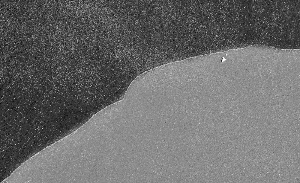 a black and white photo of a person on a surfboard