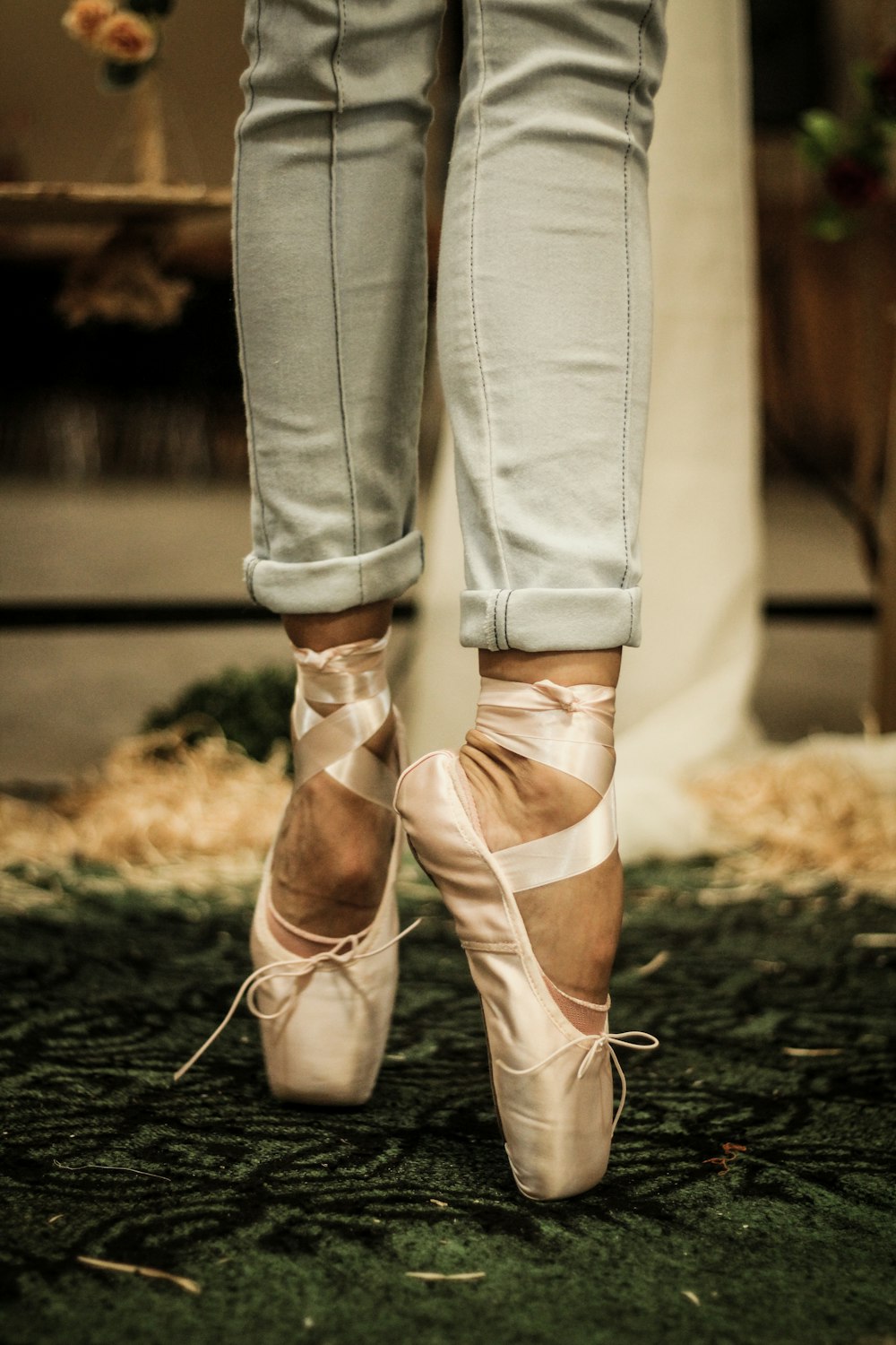 person in jeans and pink ballet shoes
