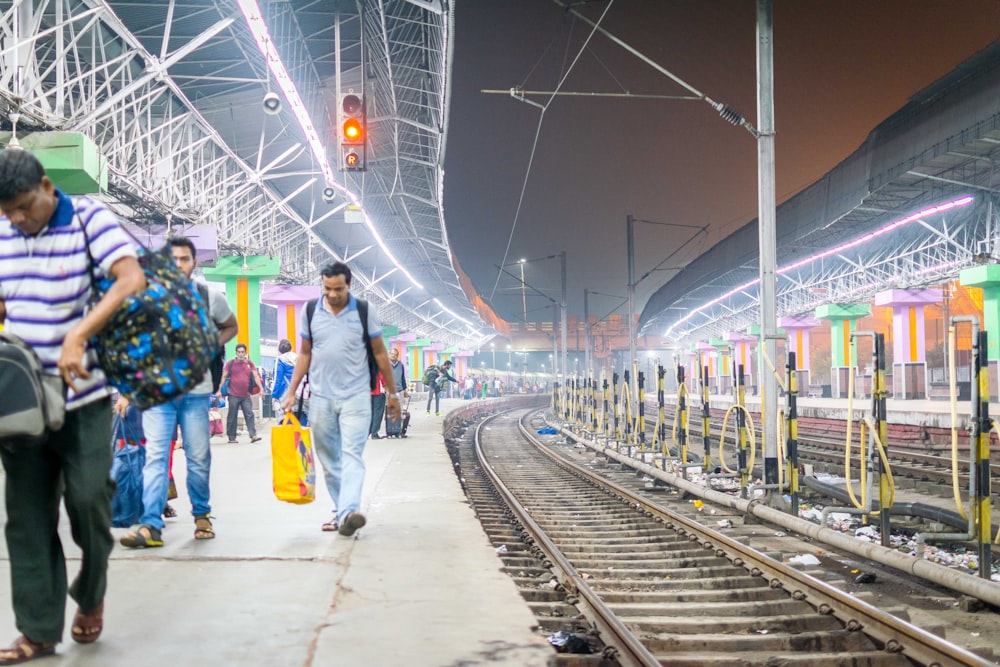 Un grupo de personas caminando a lo largo de una vía de tren