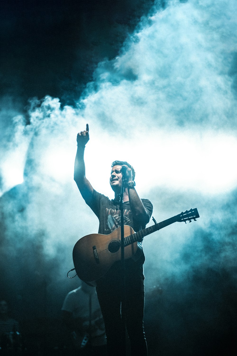 Homem se apresentando no palco com guitarra