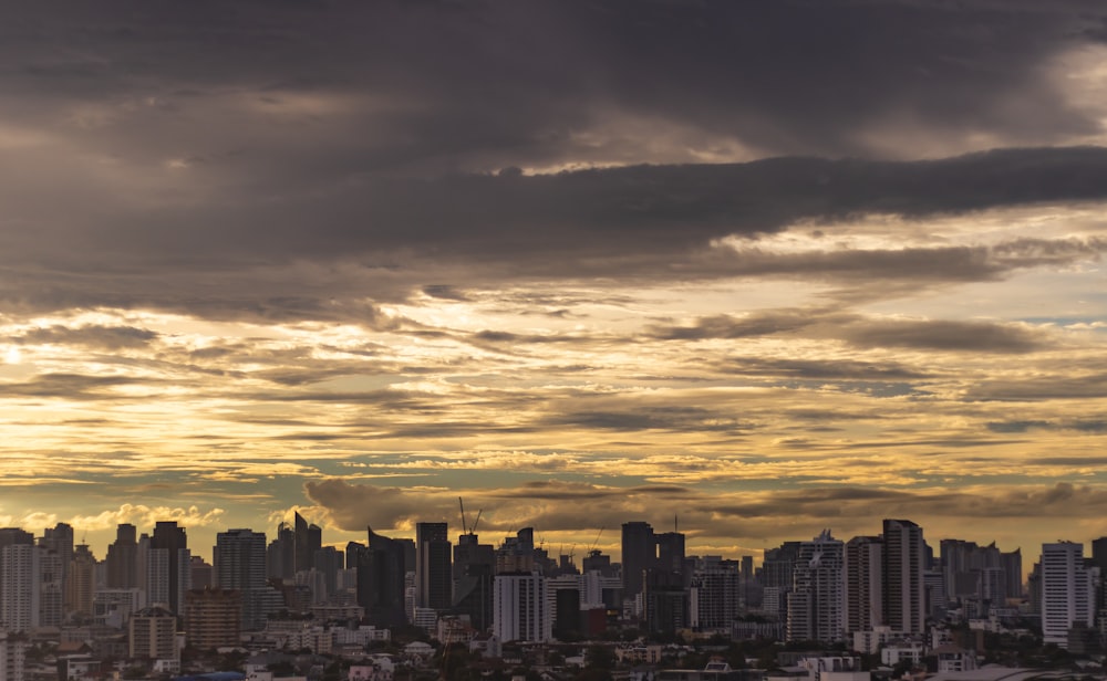 high-rise buildings under nimbus clouds