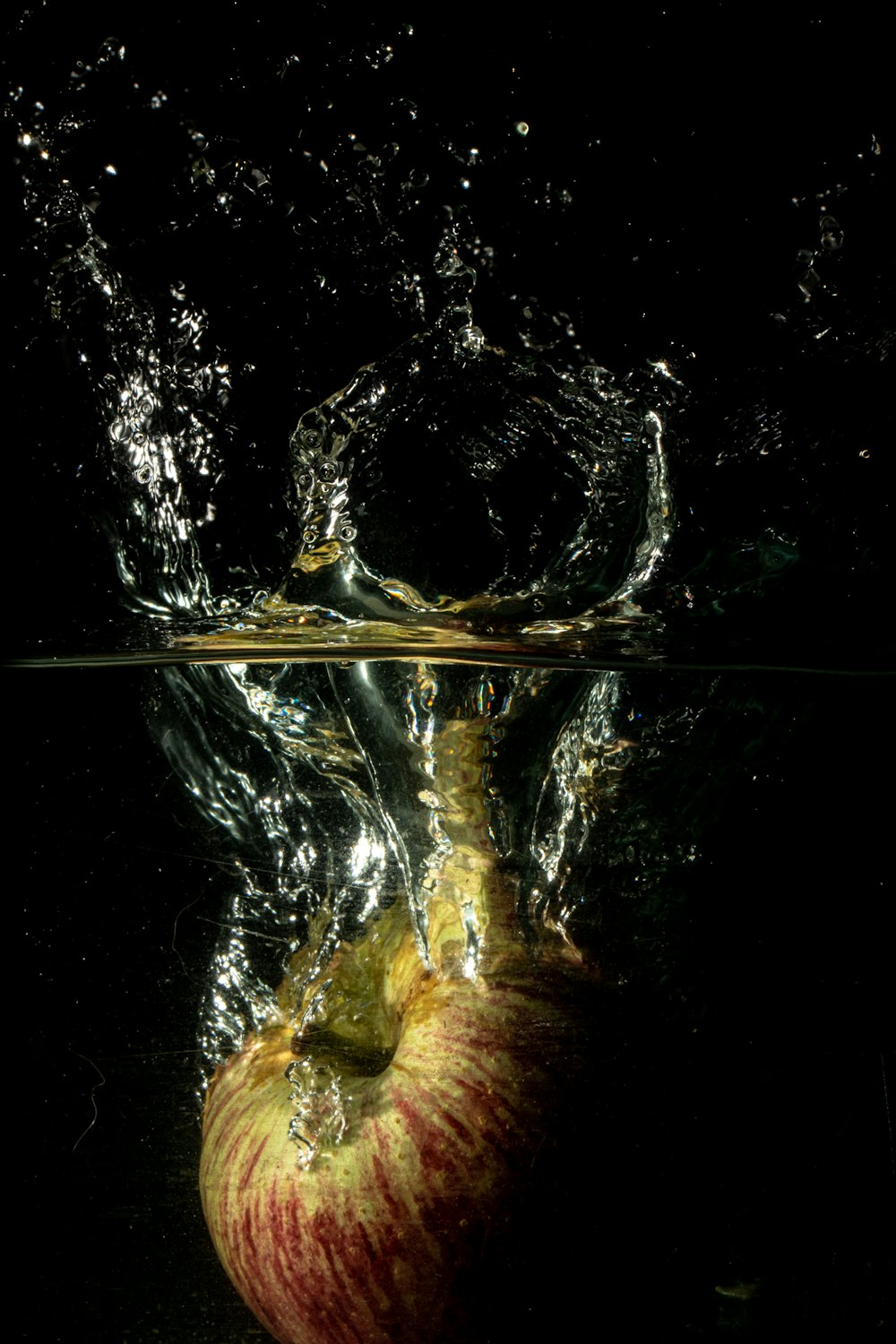 Manzana roja y amarilla bajo el agua