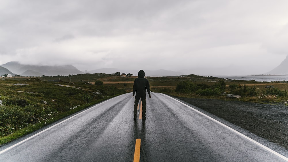 man standing in middle of road