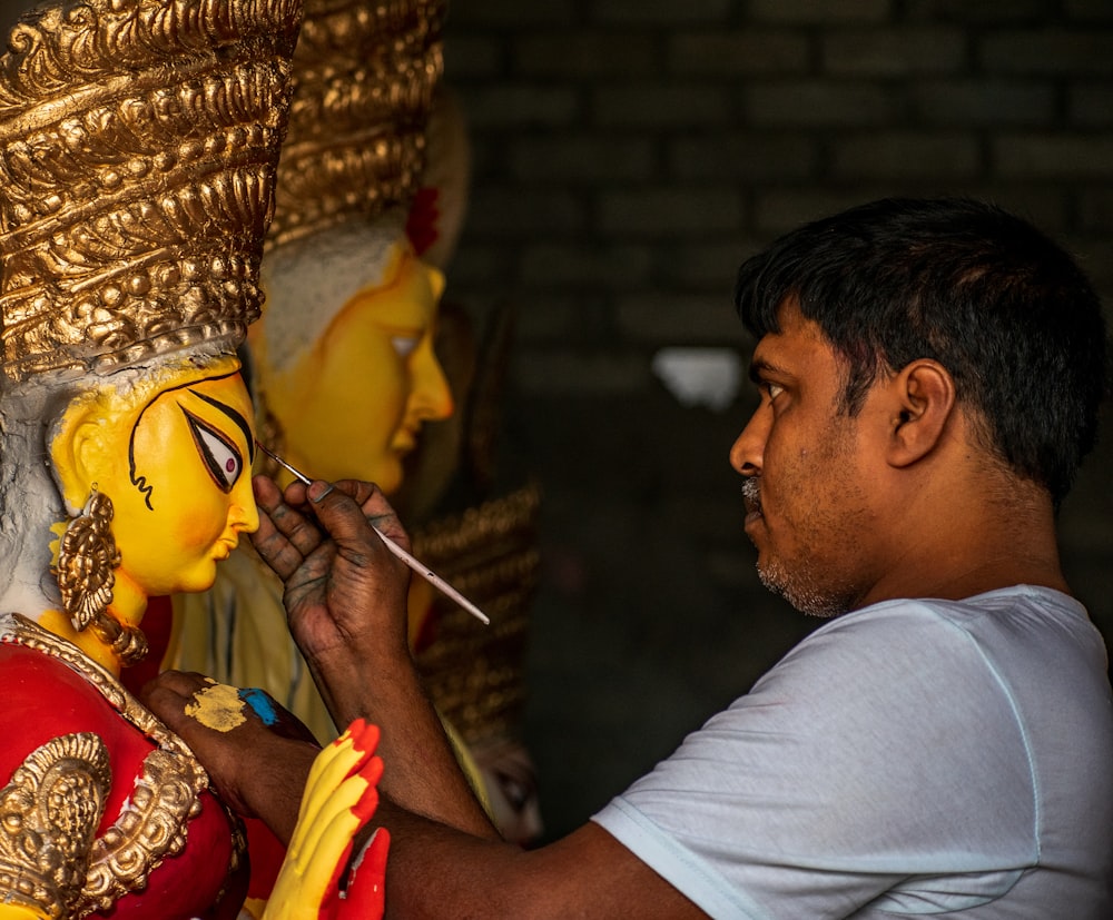 man painting statue