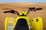 Close-up of a rider gripping the quad handles with desert mountains in the background.