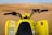 Excited rider on a quad bike speeding over golden sand dunes at Tamri Beach under a clear blue sky.