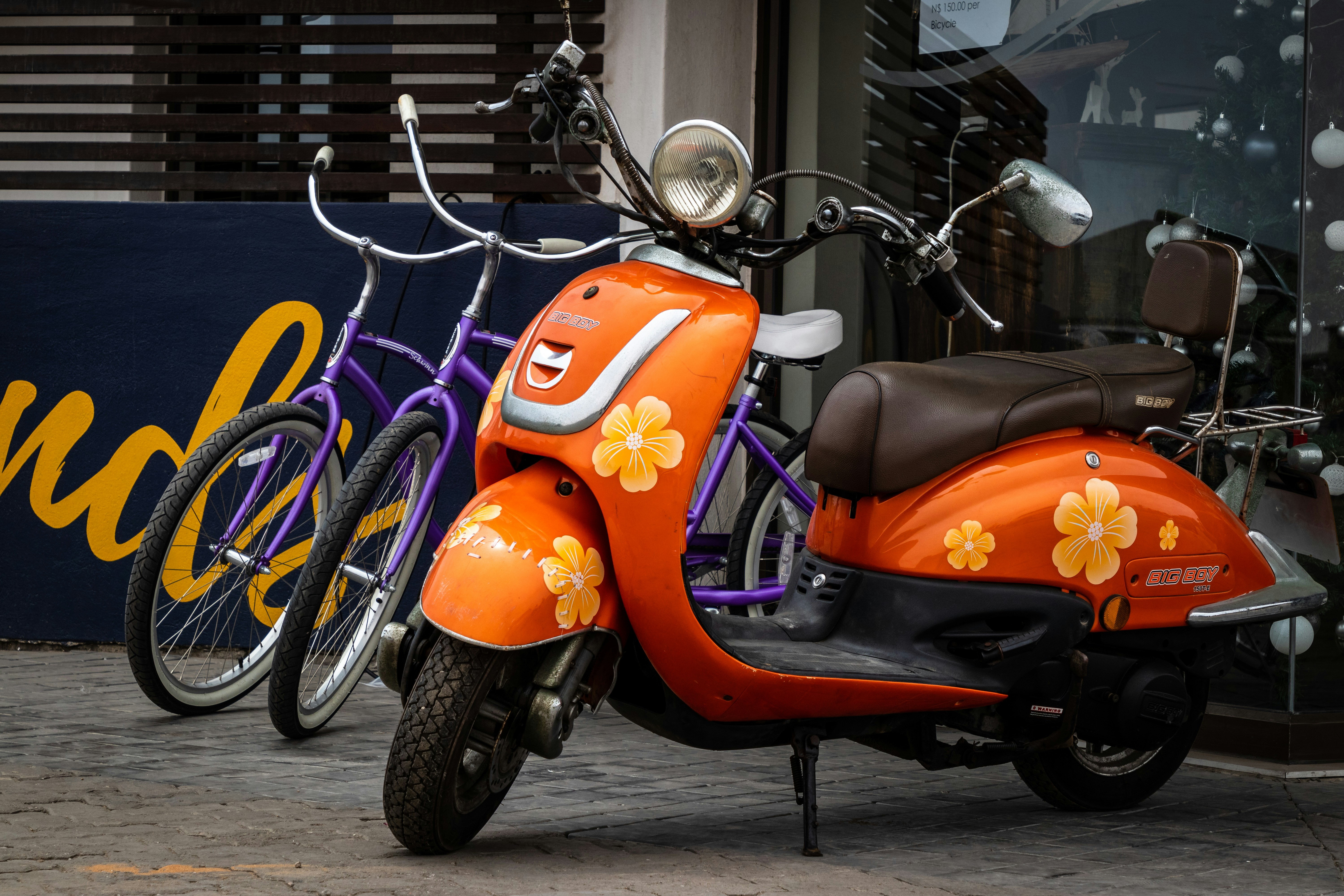 駐車場のオレンジ色の花柄のモータースクーターの写真 – Unsplashの車