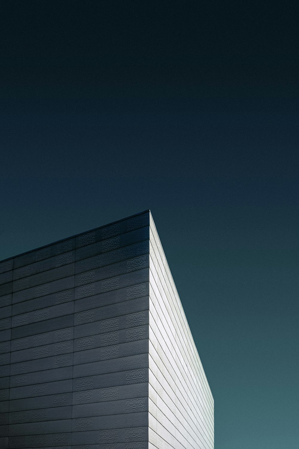 Photographie en contre-plongée d’un bâtiment en béton blanc sous un ciel bleu