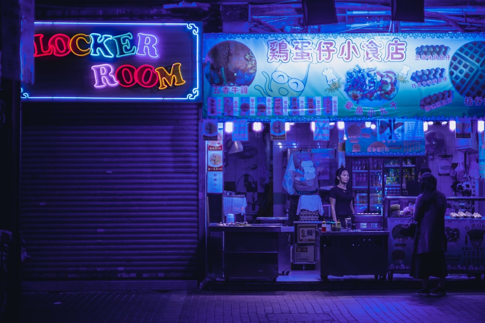 two person standing near store during night time