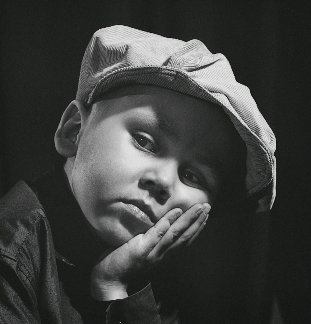 gray-scale photo of boy wearing cap