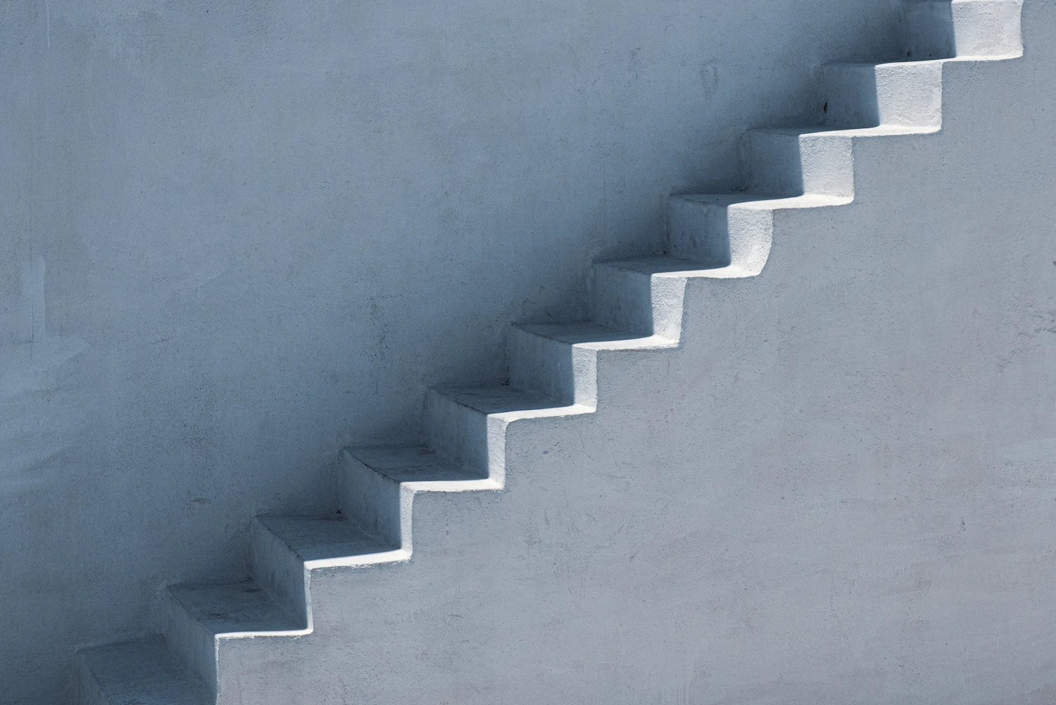 A pale concrete stair flight against a smooth wall
