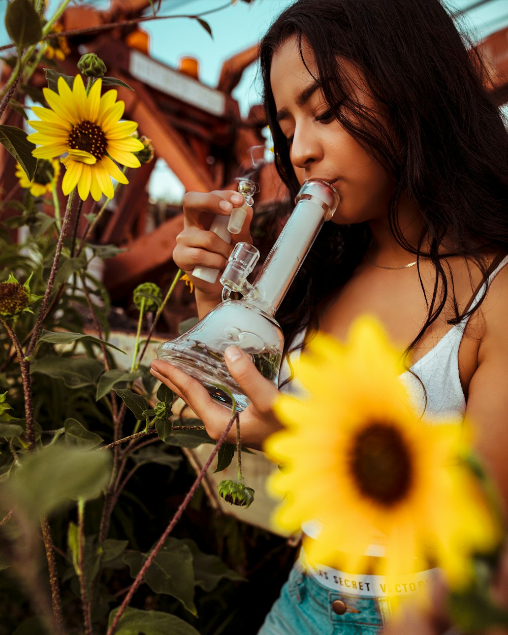 woman huffing from a glass bong