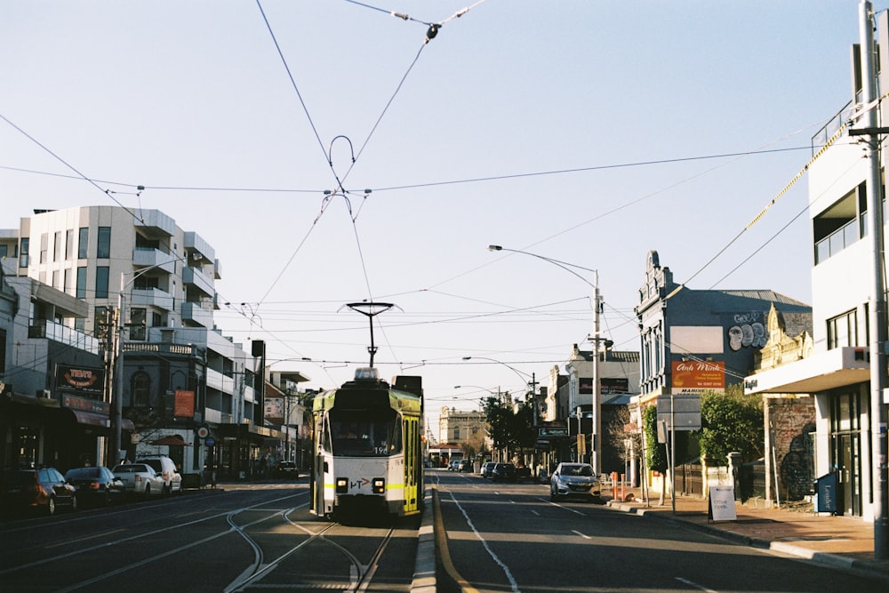 tram in road alongside building at daytime