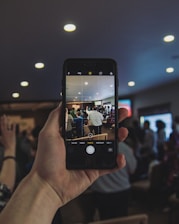 Photographer capturing a candid moment at a lively event indoors.