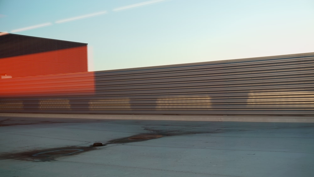 a train traveling past a tall red building