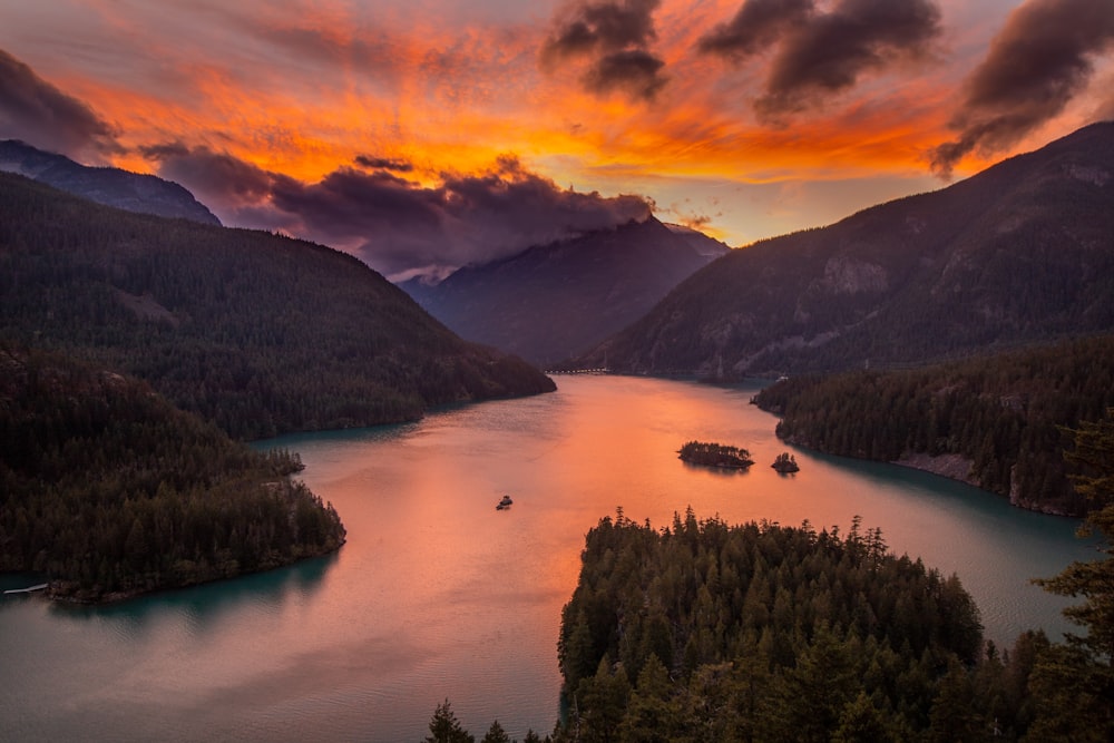 aerial photography of lake viewing mountain under orange skies