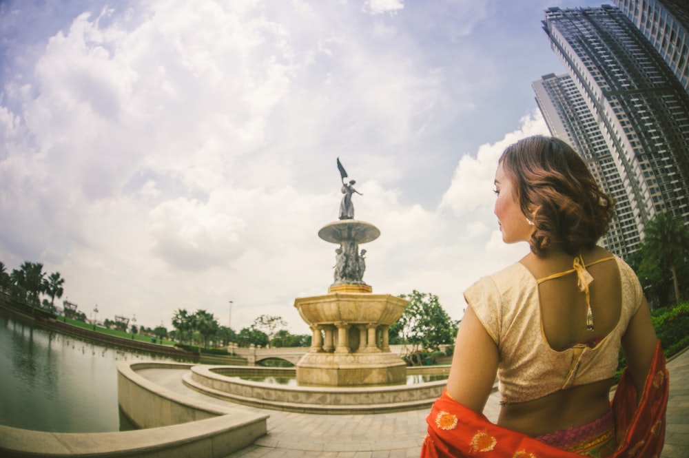 woman standing near building and fountain during daytime