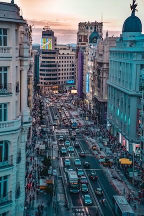 different vehicles on busy road beside high-rise buildings during daytime