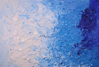 A close-up of textured layers of paint in blues and greens highlighting emotional depth.