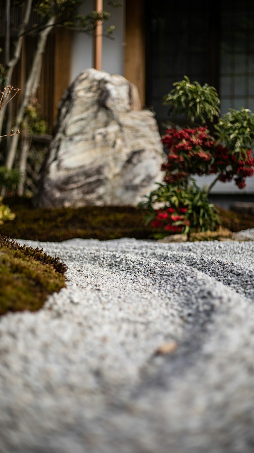 a rock and grass area in front of a house